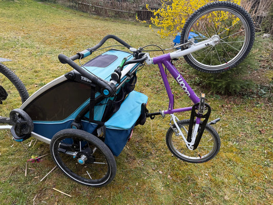 Montierter Halter für Kinderfahrrad und Laufrad am Thule Fahrradanhänger zur sicheren Befestigung